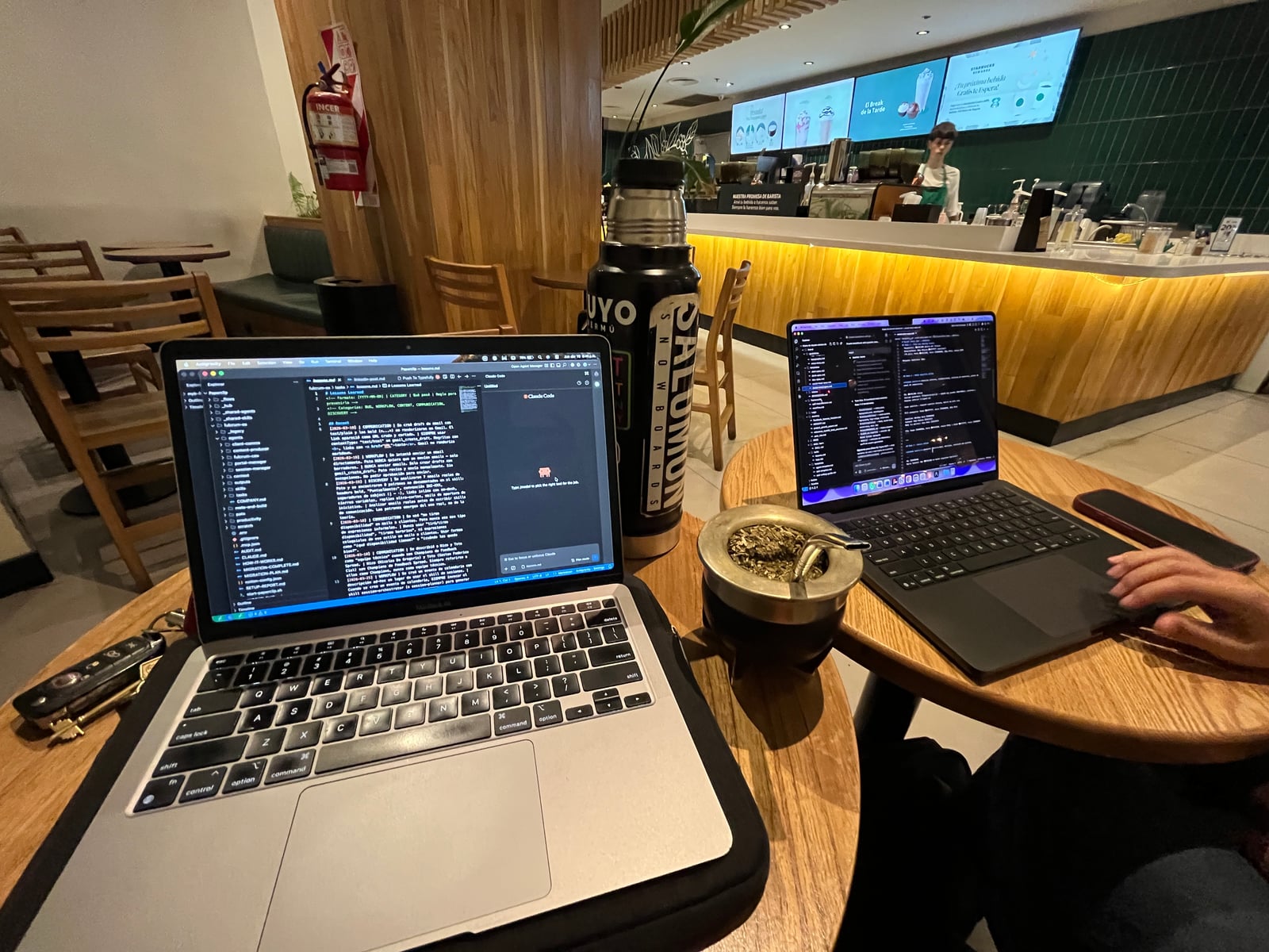 Setup de la sesión: dos MacBooks, mate y Claude Code corriendo dentro de Google Antigravity